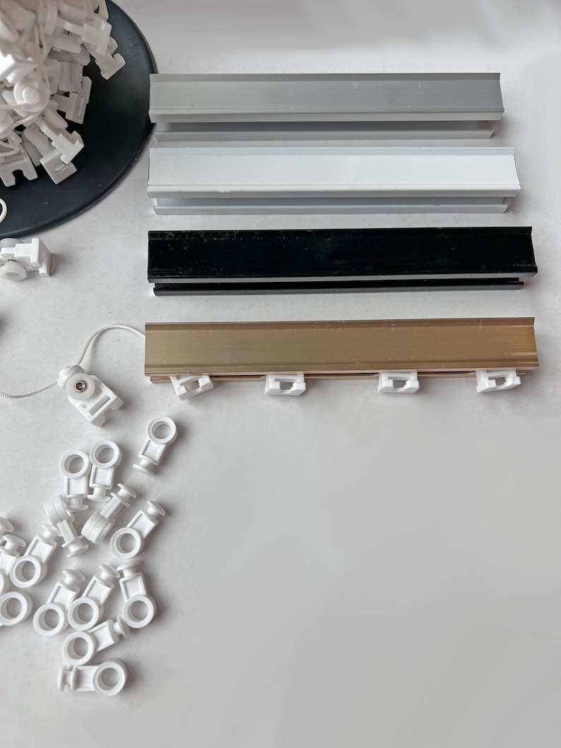All four color options of the custom aluminum ripple fold curtain track - silver, white, black and gold rails with white snap carriers and pull cord, cut to any custom width