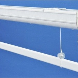 May include: White ceiling-mounted window blind system with a white metal track and white beaded chain.
