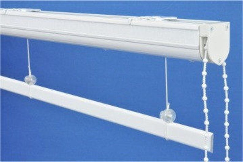 May include: White window blind with a chain mechanism. The blind is mounted to the ceiling and has a white metal track.