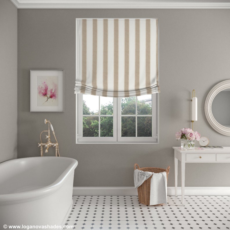 K&ouml;nnte beinhalten: Ein Badezimmer mit einer wei&szlig;en Badewanne, einem wei&szlig;en Waschtisch mit Spiegel und einem Fenster mit einem beige-wei&szlig; gestreiften r&ouml;mischen Rollo. Der Boden ist mit schwarzen und wei&szlig;en Fliesen belegt.