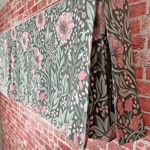 May include: A green and pink floral valance with a repeating pattern of flowers and leaves. The valance is made of fabric and has a pleated design.