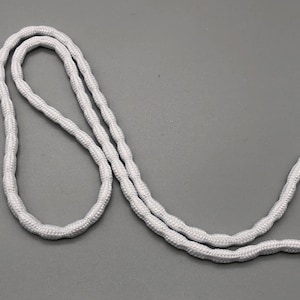 May include: White elastic cord, a type of string used for crafts, jewellery making, and other projects.