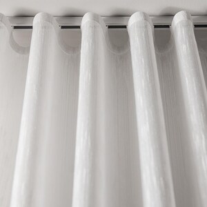 Close-up of perfect s-fold waves - sheer white curtain hanging from a slim white ripple fold ceiling track, showing the uniform wave fold heading and soft drape