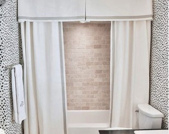 May include: White shower curtain with a gray trim and a white valance with a gray trim. The shower curtain is in a bathroom with white tile walls and a white bathtub.