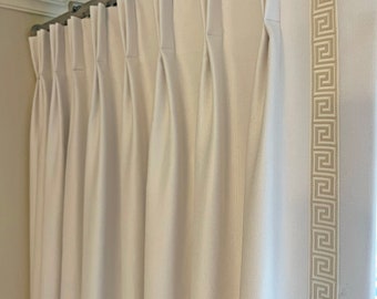 May include: White curtains with a cream-colored Greek key pattern border. The curtains are hung on a metal rod.