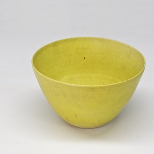 May include: A bright yellow ceramic bowl with a slightly speckled finish.