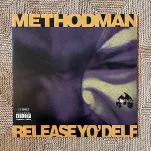 May include: A 12" single vinyl record featuring the album "Release Yo' Delf" by Method Man. The album cover has a purple and yellow color scheme with the artist's face and the Wu-Tang Clan logo. The text "METHOD MAN" and "RELEASE YO' DELF" are in yellow.