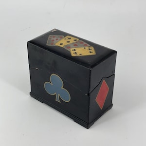 May include: A rectangular black playing card box featuring a painted design of four playing cards on the lid. The front side displays a large blue club symbol, while the right side features a red diamond symbol, all set against a smooth finish.