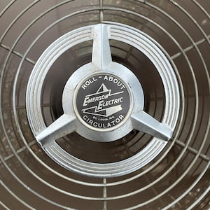 Peut inclure: Un ventilateur vintage argent&eacute; Emerson Electric Roll-About Circulator avec une &eacute;tiquette noire qui indique "Roll-About Emerson Electric St. Louis, Mo. Circulator".