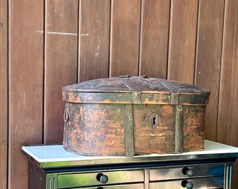Puede incluir: Una caja de madera vintage con detalles metálicos y una cerradura. La caja es marrón y tiene un acabado desgastado. Está colocada sobre una cómoda negra con varios cajones.