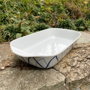 May include: White rectangular baking dish with a blue and white geometric pattern. The dish is made of ceramic and has a glossy finish.