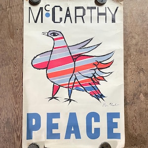 May include: Vintage poster with the word "McCarthy" above a colorful bird illustration and the word "PEACE" in blue. The bird has red, blue, and gray stripes. The poster is held in place by four metal gears.