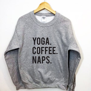 Pode incluir: Camisola de moletom cinza com o texto "YOGA. COFFEE. NAPS." impresso em preto.