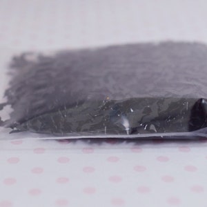 May include: A clear plastic bag with a red zipper closure filled with black confetti shaped like bats.