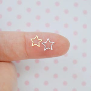 May include: Two small star-shaped charms, one gold and one silver. The charms are open and have a smooth, shiny finish.
