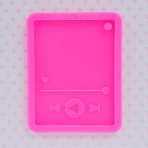 May include: Pink silicone mold shaped like a music player with a heart, play button, and rewind and fast forward buttons. The mold is for making resin crafts.
