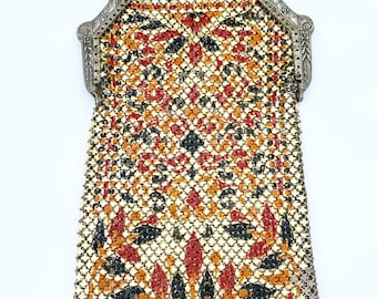 May include: A vintage silver mesh purse with a floral pattern in red, orange, and black. The purse has a silver chain strap and a decorative clasp.