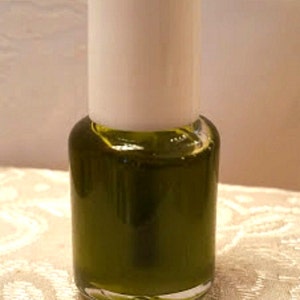 Pu&ograve; includere: Un piccolo flacone di vetro trasparente con un tappo bianco riempito di un liquido verde scuro. La bottiglia &egrave; etichettata "Pampered Skin Care".