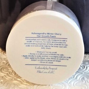 Puede incluir: Tarro blanco con tapa negra etiquetado como "Ashwagandha Winter Cherry Hair Growth Paste". La etiqueta incluye instrucciones para usar la pasta como mascarilla para el cabello o acondicionador sin enjuague. La etiqueta tambi&eacute;n dice "Exclusively by Pampered Skin Care LLC."
