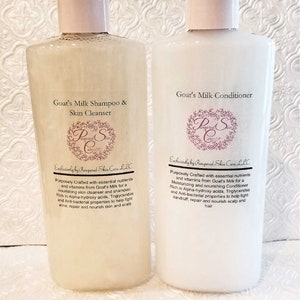 May include: Two white plastic bottles with white pump tops. The bottle on the left is labeled "Goat's Milk Shampoo & Skin Cleanser" and the bottle on the right is labeled "Goat's Milk Conditioner". Both bottles have a pink and white logo that says "Pampered Skin Care LLC".