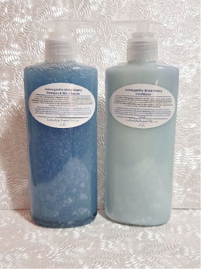 May include: Two blue plastic bottles with white labels. The labels contain the text "Ashwagandha Water Cherry Shampoo & Skin Cleanser" and "Ashwagandha White Cherry Conditioner".