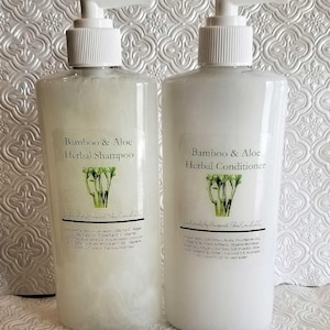 May include: Two white plastic bottles with pumps, labeled "Bamboo & Aloe Herbal Shampoo" and "Bamboo & Aloe Herbal Conditioner". Both bottles have a green bamboo plant illustration on the label.