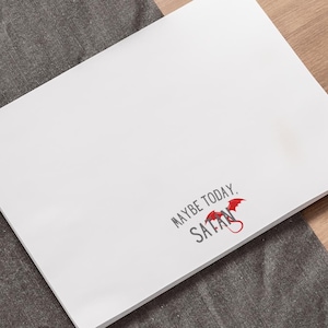 May include: White card with the text "Maybe today, Satan" in black with a red devil's tail and wings.