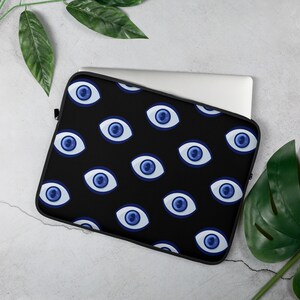 May include: Black laptop sleeve with a repeating pattern of blue evil eyes.