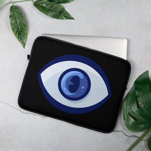 May include: Black laptop sleeve with a blue and white evil eye design. The evil eye is a symbol of protection against negative energy.