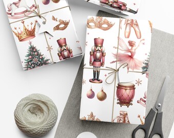 Op de afbeelding: Wit cadeaupapier met een patroon van notenkrakers, kronen en balletdansers. De cadeaus zijn vastgebonden met touw. Een kluwen touw, een schaar en cadeaulabels zijn ook zichtbaar.
