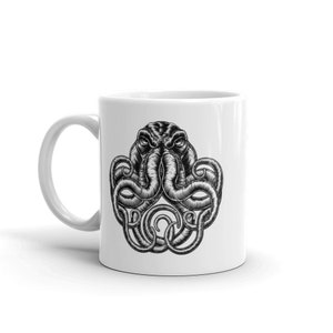 May include: White ceramic coffee mug with a black and white illustration of an octopus with its tentacles wrapped around its head.