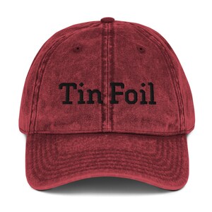 Pode incluir: Um bon&eacute; de beisebol vintage vermelho com o texto "Tin Foil" bordado em preto.