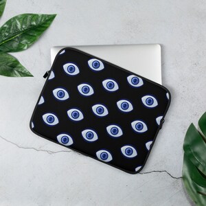 May include: Black laptop sleeve with a repeating pattern of blue evil eyes. The sleeve is made of a soft, durable material and is designed to protect your laptop from scratches and bumps.