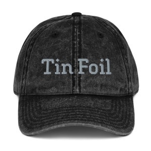 Pode incluir: Um bon&eacute; de beisebol de brim vintage preto lavado com o texto "Tin Foil" bordado em branco na frente.