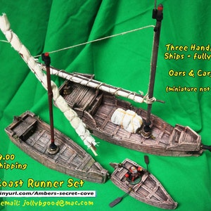May include: The Coast Runner Set includes three hand-painted miniature ships, fully rigged with oars and cargo. The ships are made of wood and have a weathered appearance. The set includes the text "The Coast Runner Set" and the URL "http://tinyurl.com/Ambers-secret-cove".