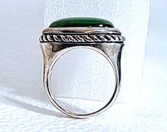 May include: A silver ring with a dark green, oval-shaped stone. The stone is set in a silver band with a rope-like design around the stone. The ring is a size 8.