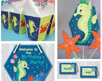 May include: A collection of party supplies with a sea life theme. Includes popcorn boxes, cupcake wrappers, party hats, signs, and photo booth props. Designs feature seahorses, octopuses, starfish, and crabs. Text includes "Welcome to the Birthday Party!" and "Happy Birthday!"