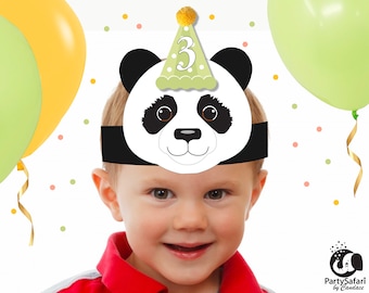 Op de afbeelding: Een kind draagt ​​een panda-feestmuts met een groen en wit ontwerp en het nummer "3" erop. De muts heeft een zwart hoofdband en een wit panda-gezicht met zwarte ogen en een zwarte neus. Het kind glimlacht en draagt ​​een rood shirt.