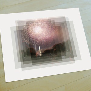 May include: A photograph of fireworks exploding over a city skyline at night. The fireworks are pink, white, and yellow. The city skyline is dark and silhouetted against the night sky.