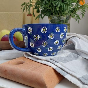 Daisy mug on a wooden cutting board, shown from a different angle