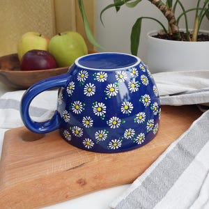 Close-up of the white rim and handle of the daisy mug