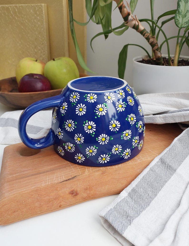 Close-up of the white rim and handle of the daisy mug