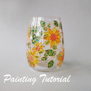 Pode incluir: Um vaso de vidro transparente com um desenho pintado de girassóis e folhas em tons de amarelo, verde e laranja. O vaso é decorado com um contorno dourado em torno das flores e das folhas.  "Painting Tutorial" está escrito em branco na parte inferior da imagem.