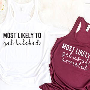 May include: Three tank tops with white text on different colored backgrounds. The text on the pink tank top reads "MOST LIKELY TO wander off to take a nap". The text on the white tank top reads "MOST LIKELY TO get hitched". The text on the maroon tank top reads "MOST LIKELY TO get us all arrested".