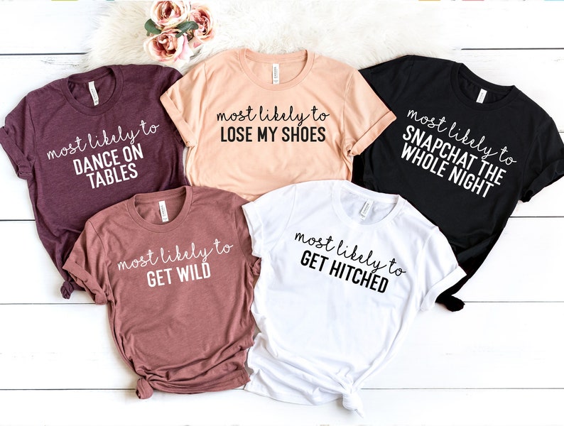 Peut inclure: Cinq t-shirts avec des slogans diff&eacute;rents. Les slogans sont "most likely to dance on tables", "most likely to lose my shoes", "most likely to Snapchat the whole night", "most likely to get wild", et "most likely to get hitched".