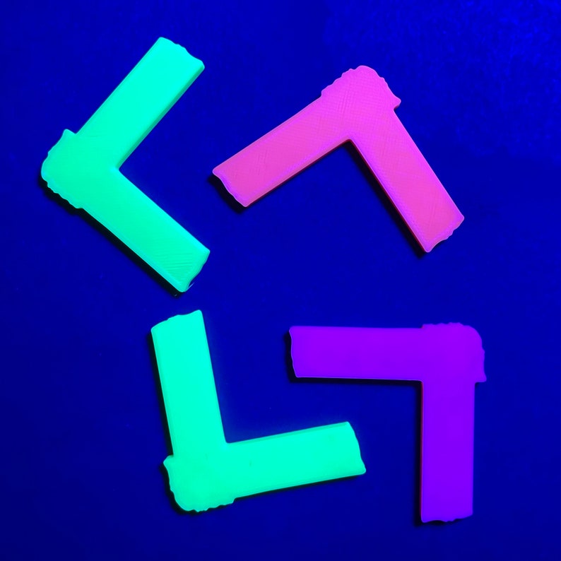 May include: Four plastic corner pieces in different colors: green, pink, and purple. The corner pieces are arranged in a star shape on a blue background.