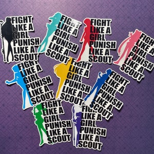 May include: Nine colourful stickers with the text "Fight Like A Girl Punish Like A Scout" in black text. Each sticker features a silhouette of a girl in a different colour: blue, green, yellow, pink, red, black, light blue, dark blue, and purple.