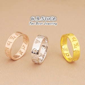 May include: Three gold rings with intricate designs. The rings are in different colors: rose gold, silver, and yellow gold. The rings have a repeating pattern of symbols.