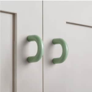 May include: Two light green cabinet door handles in the shape of a rounded 'C'.