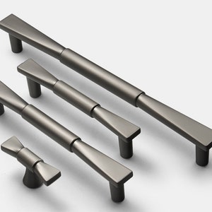 Puede incluir: Cuatro tiradores de armario de níquel cepillado de diferentes tamaños con un diseño moderno y geométrico. Los tiradores tienen una forma rectangular plana con un ligero estrechamiento en los extremos.